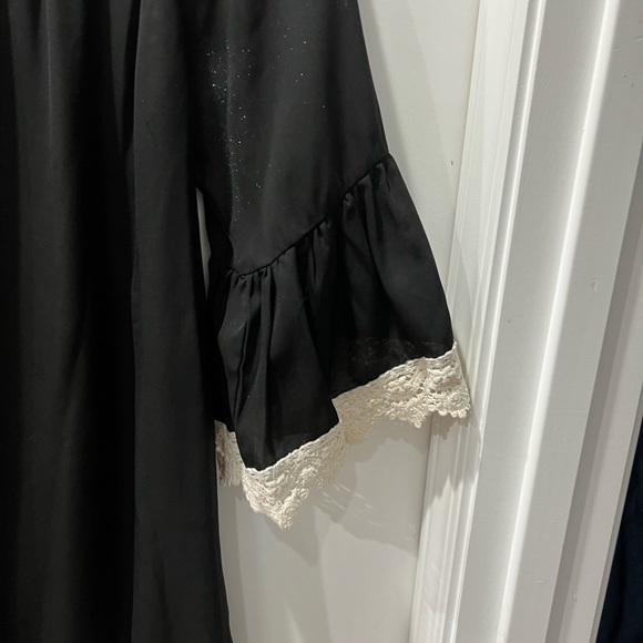 Black top with bell sleeves and lace trim. - Picture 2 of 4